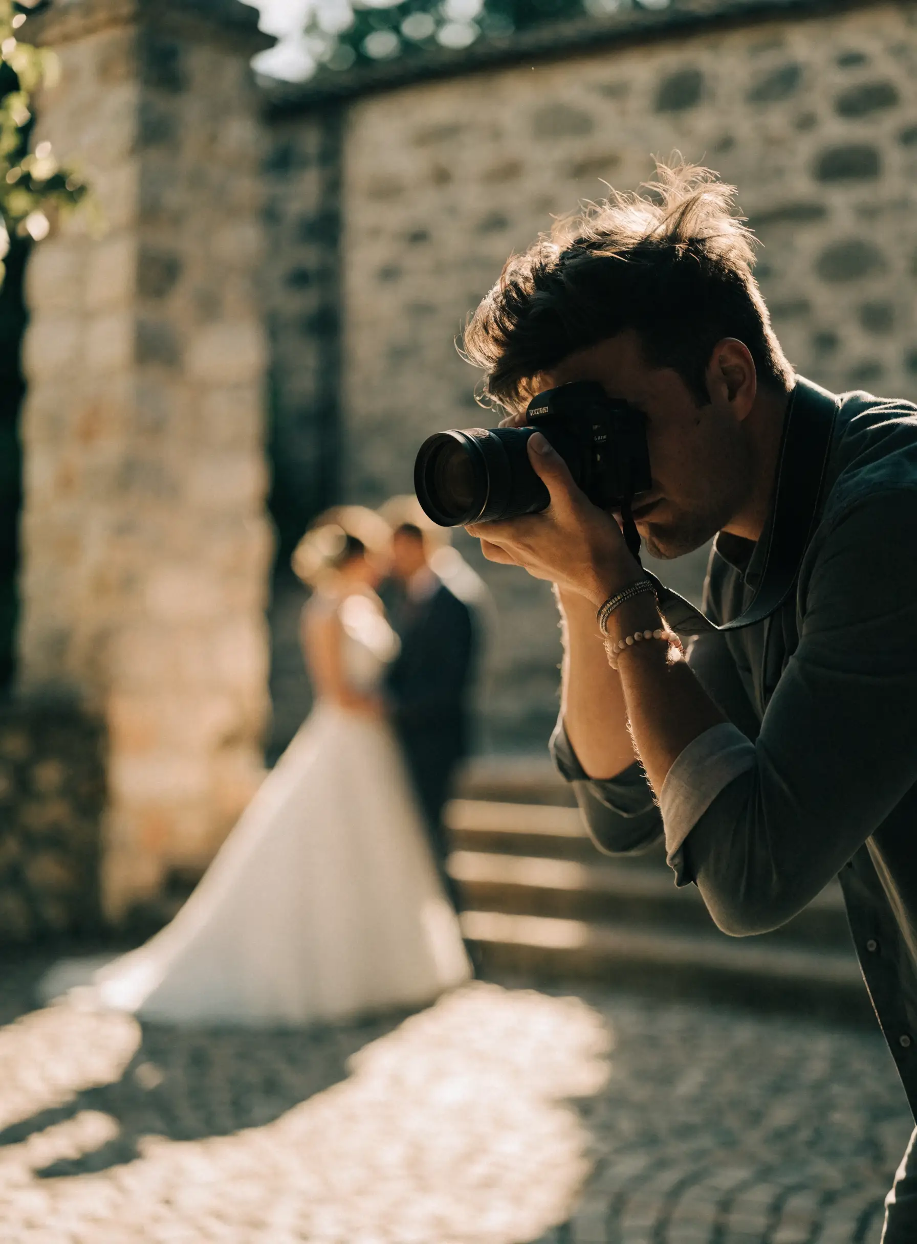 A wedding photographer at work in a courtyard at golden hour